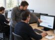 KI-Schulung für Unternehmen: Ein Trainer begleitet Mitarbeiter bei der Prüfung einer KI-generierten Antwort am Bildschirm.