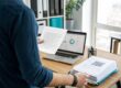 KI-SEO: Mann prüft Unternehmensdokumente mit QR-Code und checkt KI-Content-Konformität in hellem Büro.
